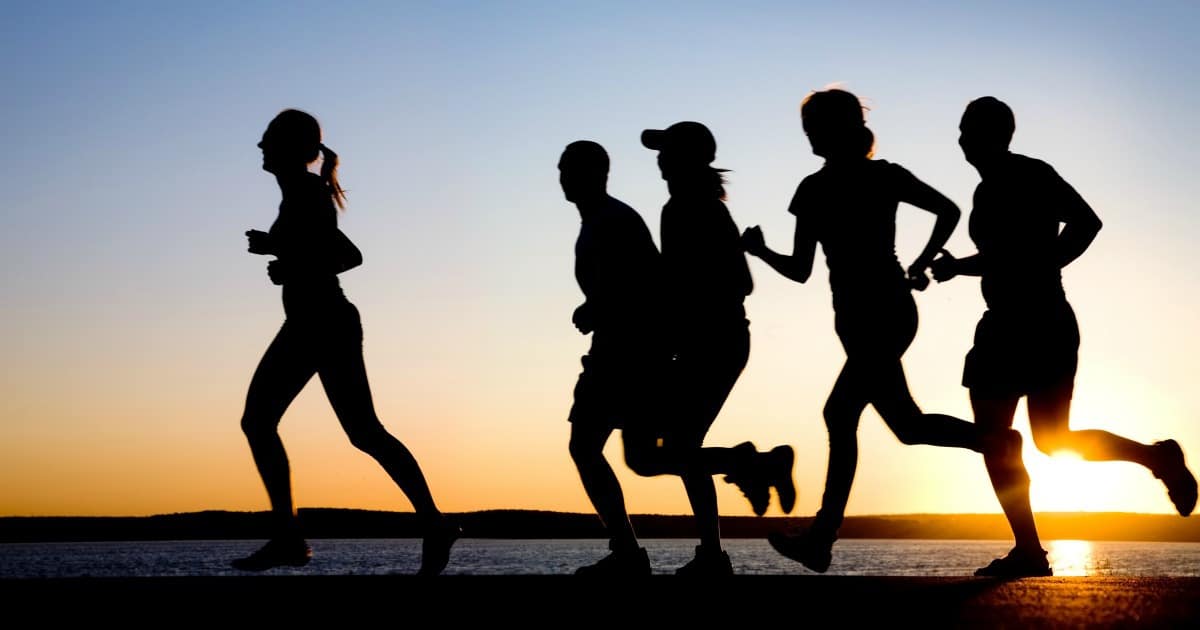 Team of people running at sunset